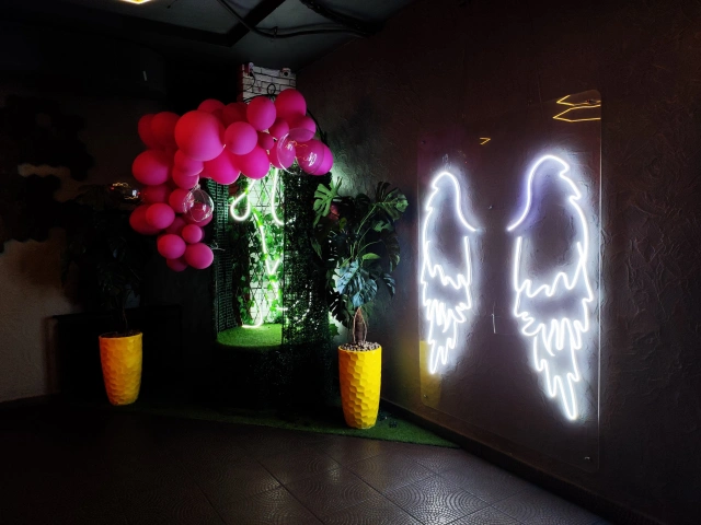 Фотозона со светящимися крыльями в клубе Доски